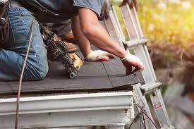 Worker_on_a_ladder_installing_shingles_on_a_roof_with_a_nail_gun.

