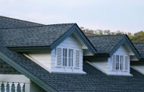 Close_up_of_a_house_roof_with_two_white_dormer_windows.

